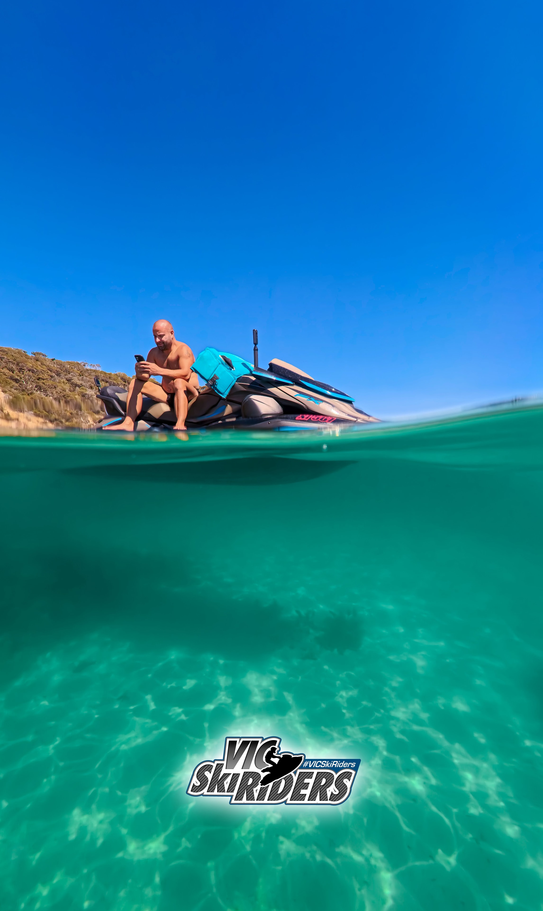 Rider sitting on a Sea-Doo in crystal clear water, split underwater shot